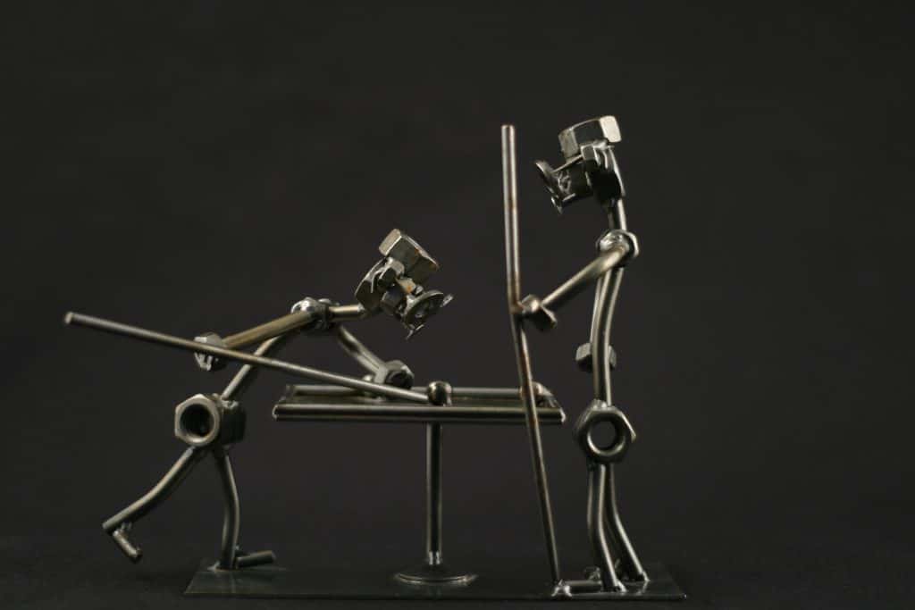 two metallic figures playing billard